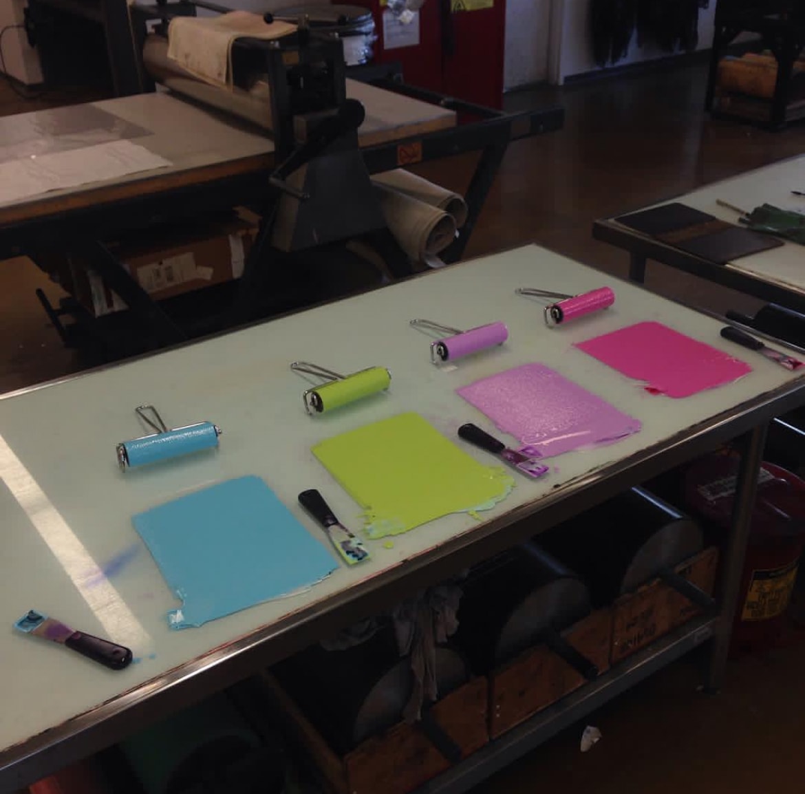 Ink rollers and color swatches on printmaking table
