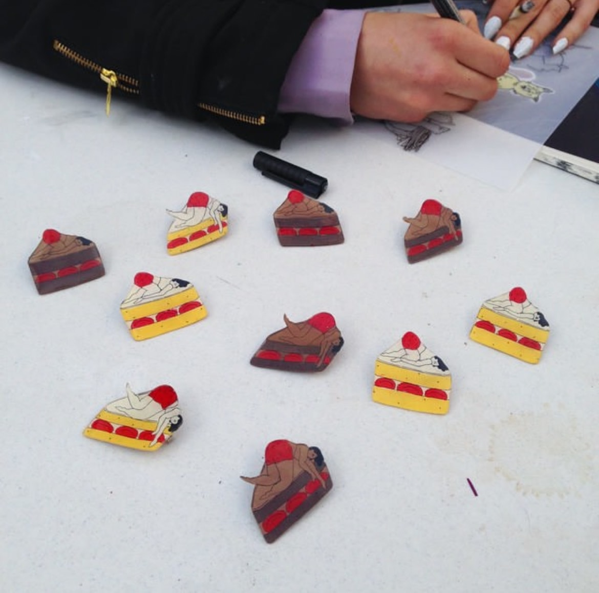 Colorful cake slice pins being drawn at a table
