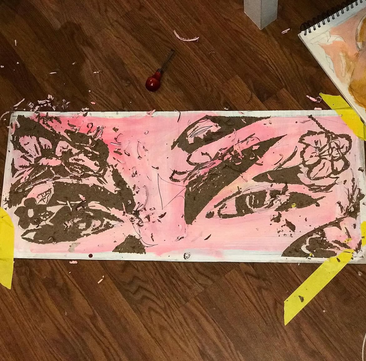 Carved woodblock with pink ink on studio floor
